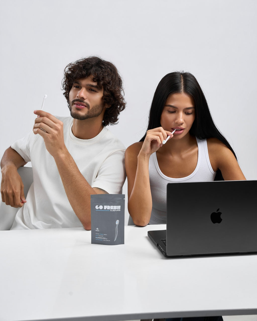 Two colleagues at a desk with a Go Fresh Minis 6-pack